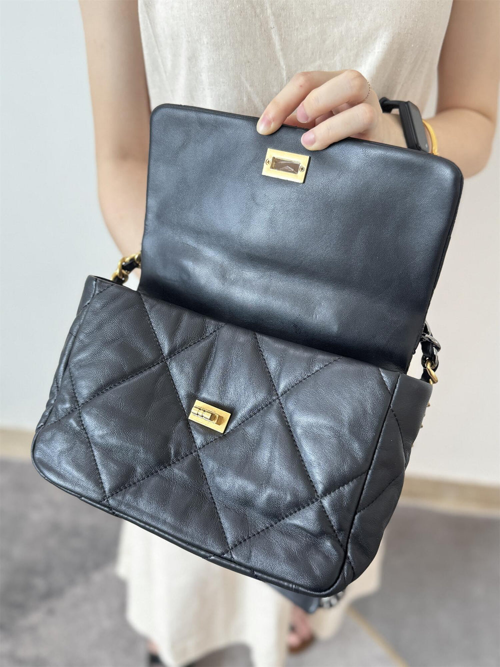 Black quilted lambskin leather shoulder bag with gold chain lock, shown open