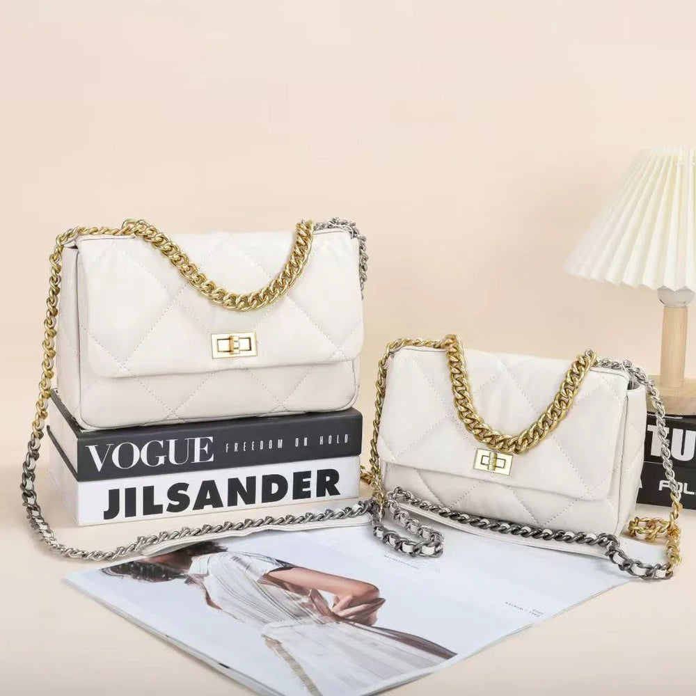 Quilted white leather shoulder bags with gold chain straps and turn-lock closures, styled on books and magazines