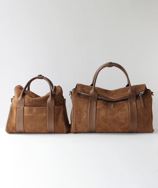 Two brown suede duffel bags in different sizes, displayed side-by-side against a plain light gray background.