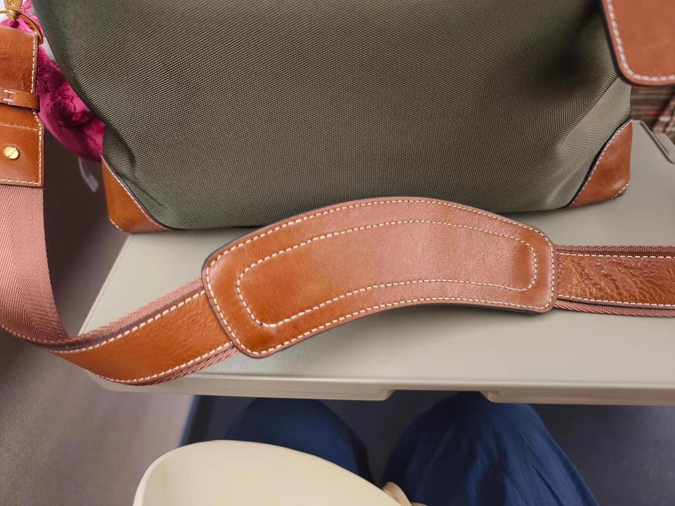 Close-up of a waterproof nylon and cowhide tote bag with leather strap on a table.