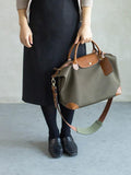 Woman holding olive green waterproof nylon and cowhide tote bag with leather handles