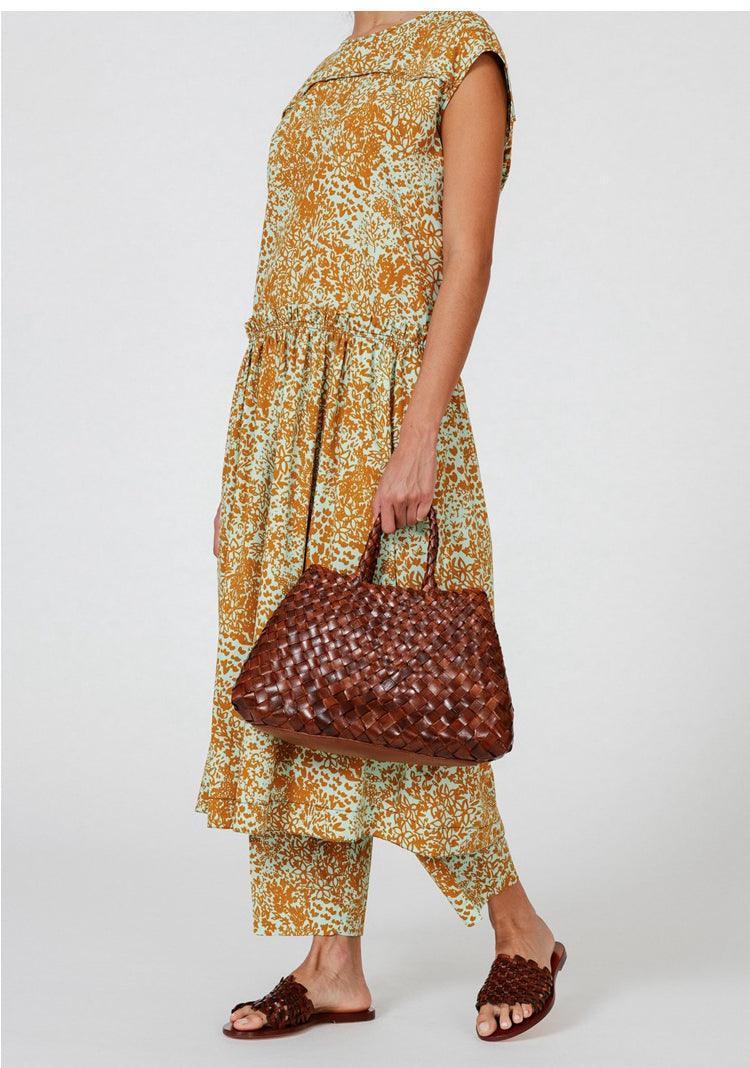 Woman carrying a dark brown woven leather hobo bag with trapezoidal shape Tan Brown