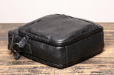 Black leather men's crossbody shoulder bag with textured finish on wooden surface