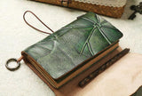 Green embossed leather sketchbook with textured cover and keyring, on a neutral surface