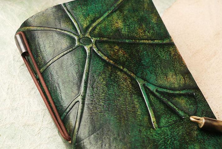 Green leather journal with embossed abstract design and brown elastic closure