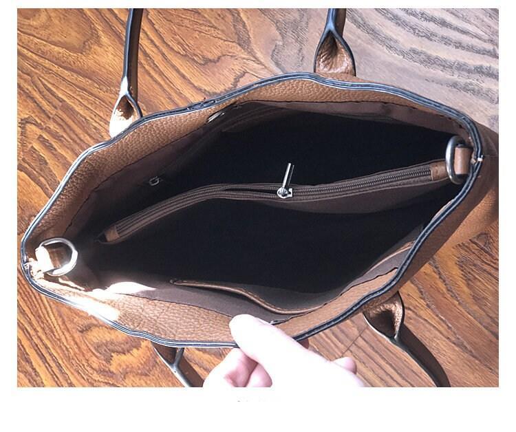 Interior of large brown leather tote bag with zippered pocket and open compartments