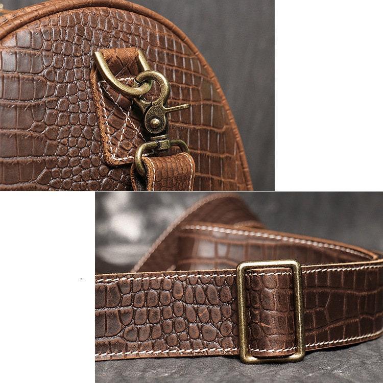 Close-up of brown crocodile-embossed full-grain leather duffle bag with brass hardware