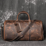 Full grain brown leather duffle bag with shoulder strap and luggage tag, cowhide texture