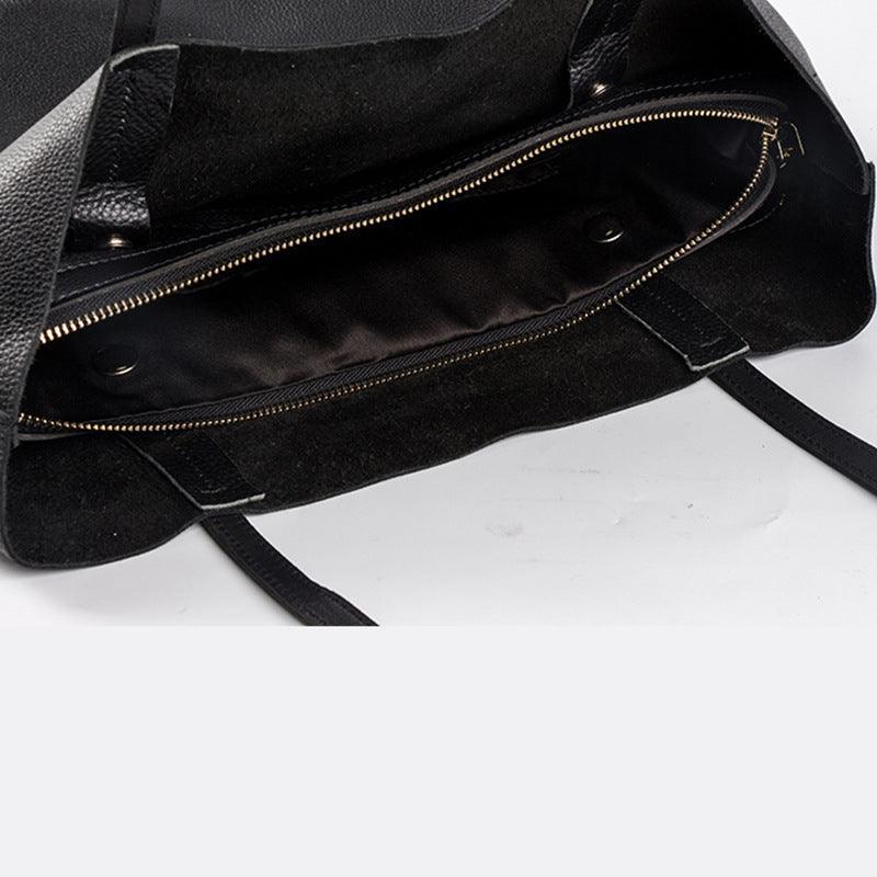 Black full grain leather tote bag with spacious interior and zippered pocket