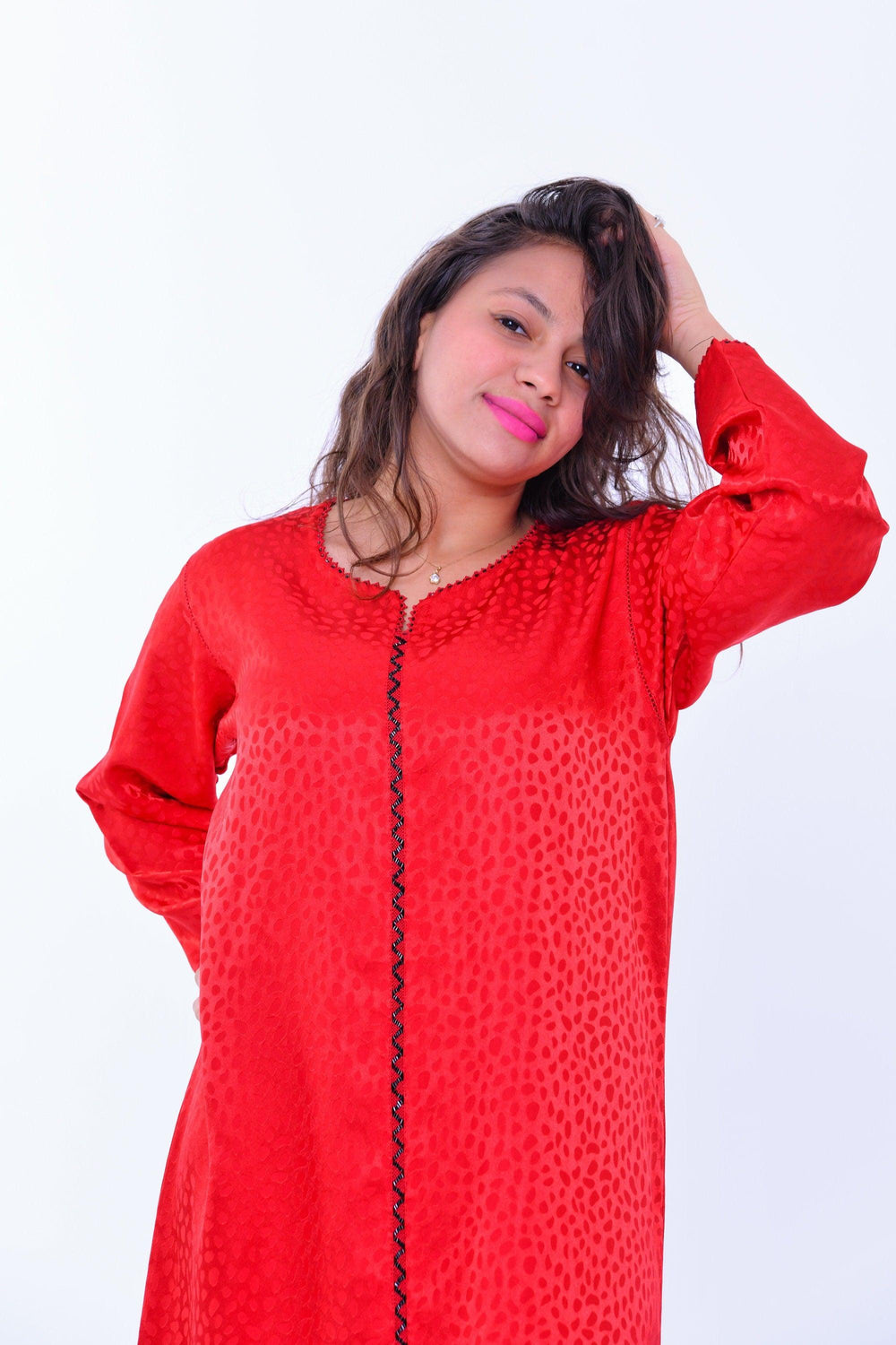 Woman wearing a red silk boho kaftan dress with wide sleeves and subtle ethnic pattern