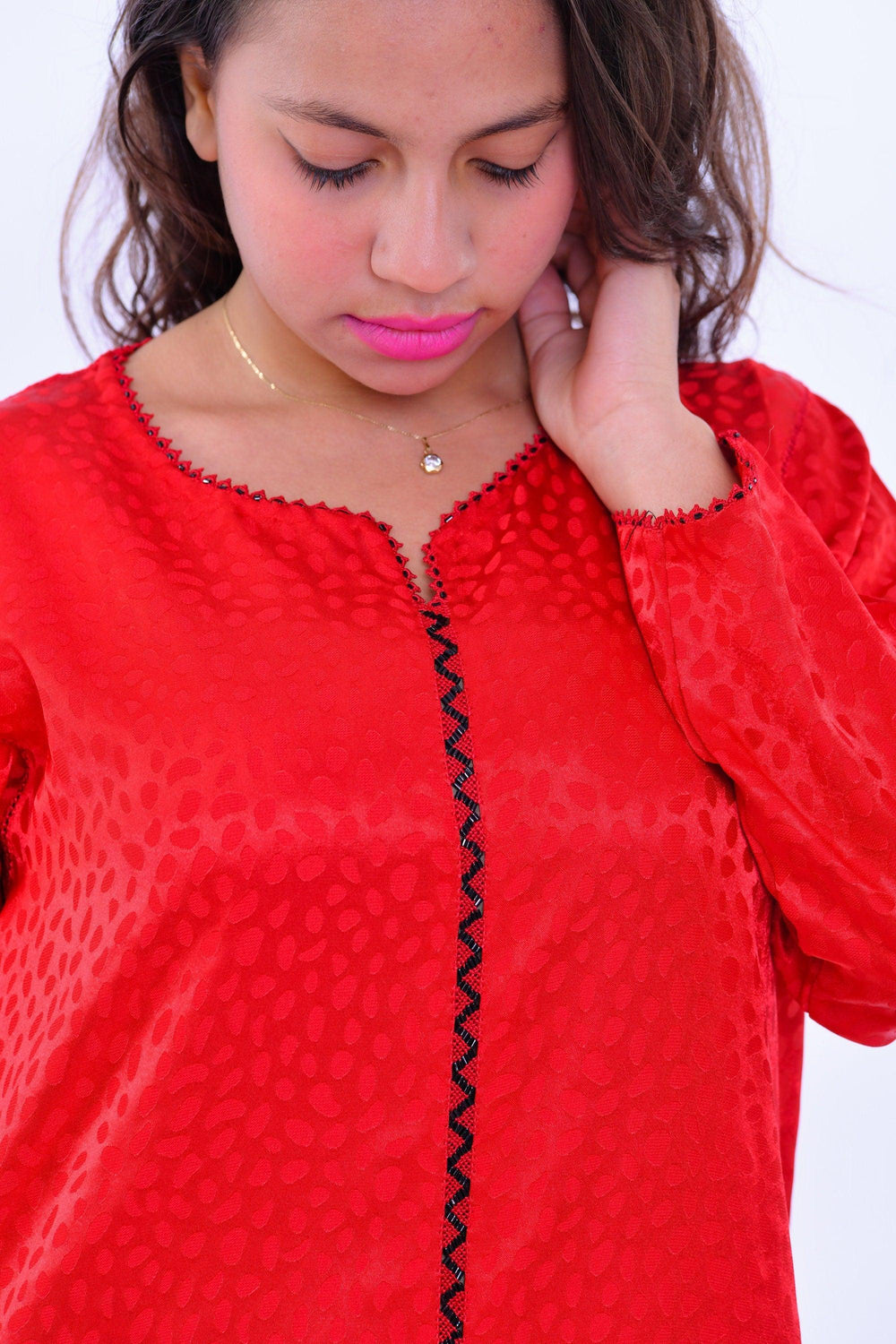 Woman wearing red boho silk kaftan dress with wide sleeves and subtle pattern details
