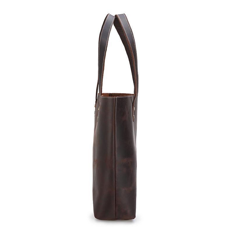 Side view of a large handcrafted dark brown leather tote bag with double handles