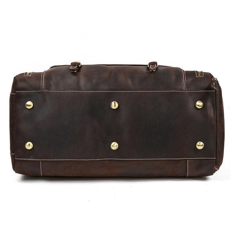 Bottom view of dark brown full grain leather duffle bag with metal feet and white stitching