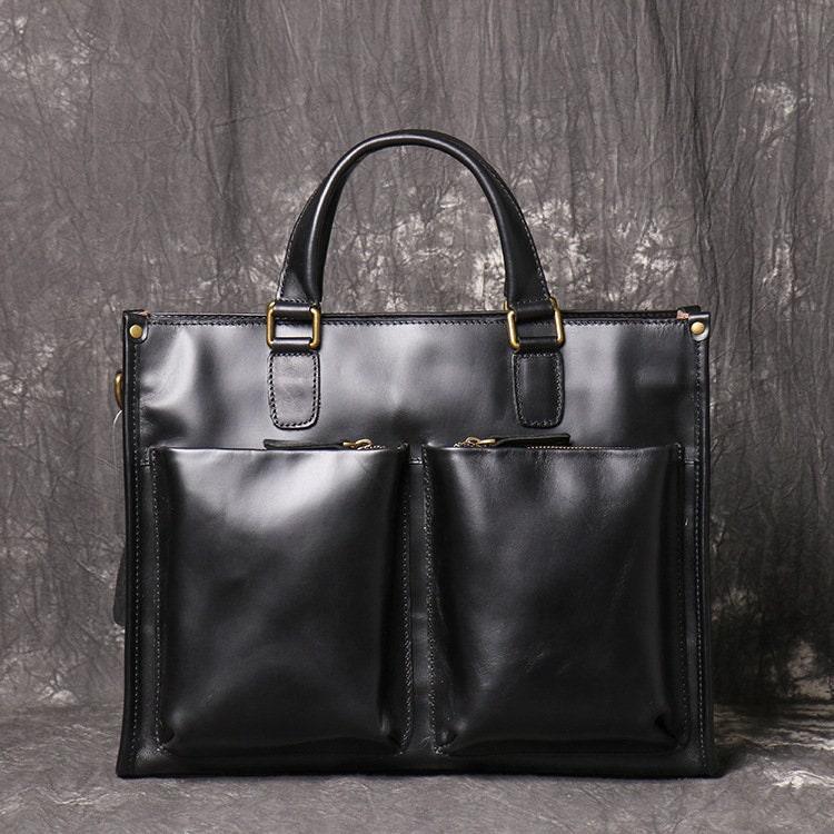 Black full grain leather messenger bag with dual front pockets and top handles