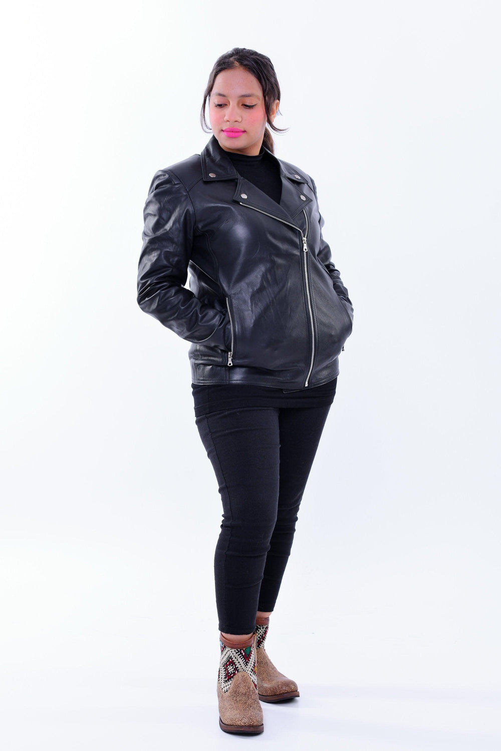 Woman wearing a black genuine leather slim-fit biker jacket with zip pockets.