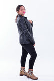 Woman wearing slim fit black genuine leather biker jacket and patterned ankle boots