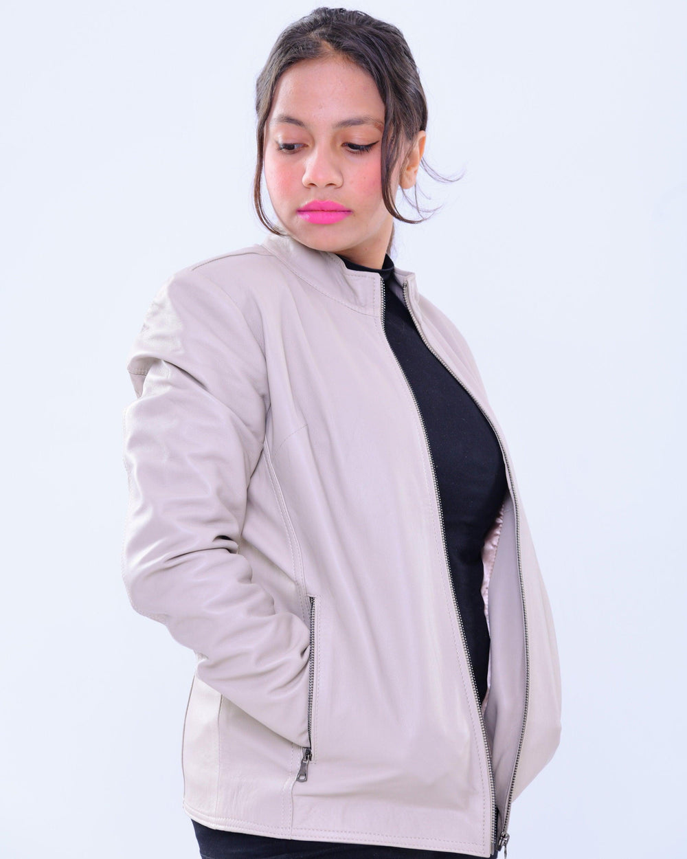 Woman modeling slim fit genuine leather biker jacket in light grey with zip pockets
