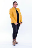 Woman wearing a yellow slim fit genuine leather biker jacket with black pants and patterned boots.