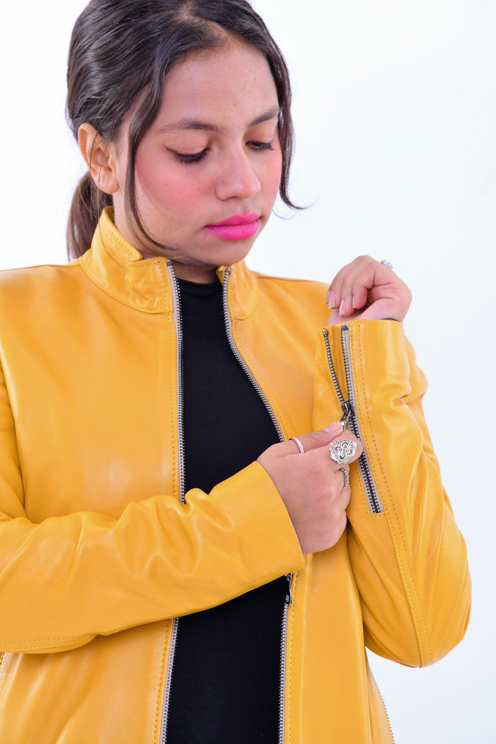 Woman wearing slim fit yellow genuine leather biker jacket with zipper details
