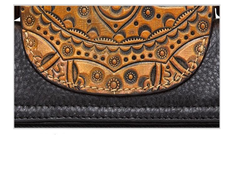 Close-up of a black leather handbag with an embossed floral brown leather flap