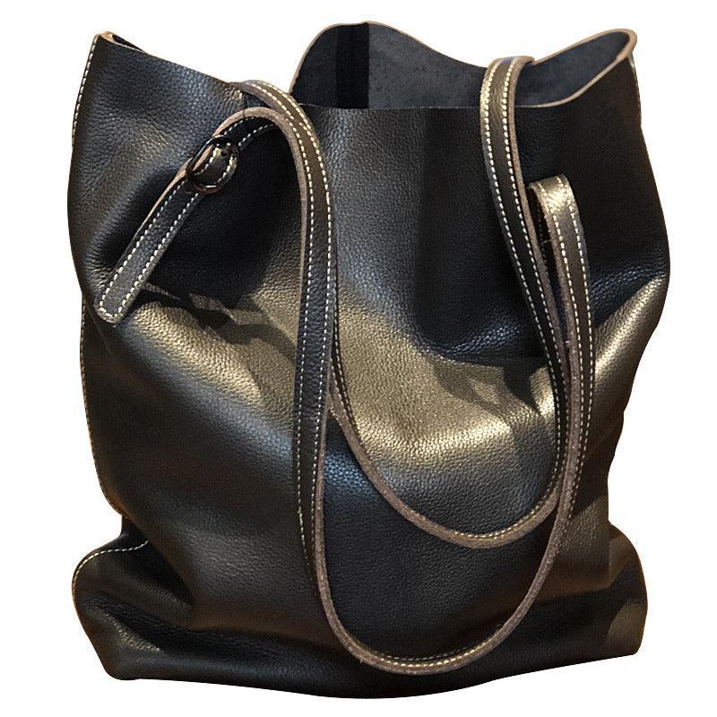 Large black leather tote bag with long double handles and visible topstitching