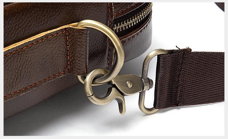 Close-up of brown leather shoulder bag with metal clasp and detachable strap