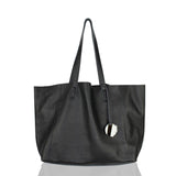 Black full grain leather tote bag with double handles and hanging keychain on white background