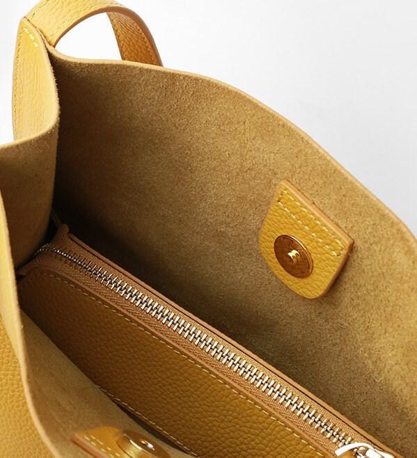 Interior view of tan grain cowhide leather tote bag with zippered pocket and snap closure