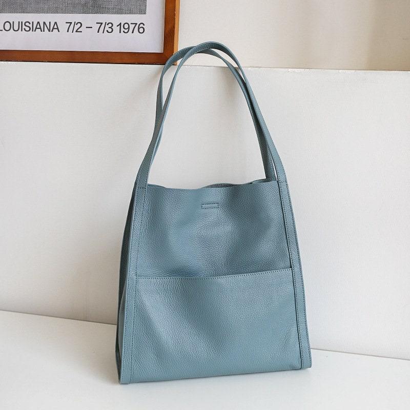 Light blue grain cowhide leather tote bag with double shoulder straps on white background