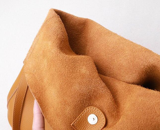 Close-up of soft brown cowhide leather tote bag with suede interior and snap closure