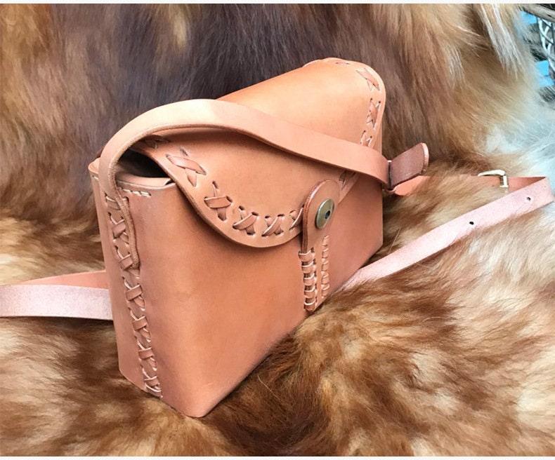 Small handcrafted tan leather shoulder bag with crossbody strap and decorative stitching