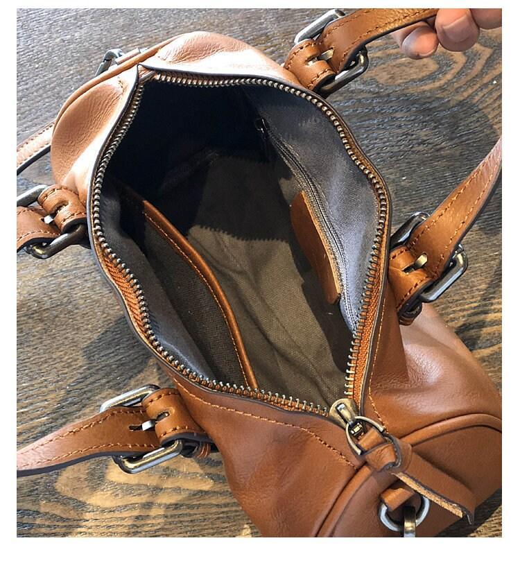 Open brown vintage leather Boston bag with zip closure, showing spacious interior and pockets